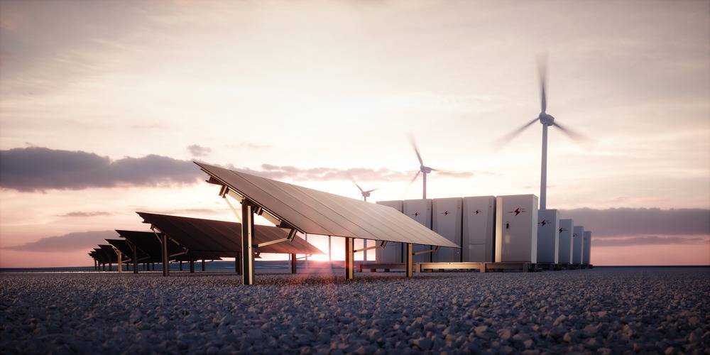 Sunset scene showing a solar panel, a wind turbine, and battery storage.