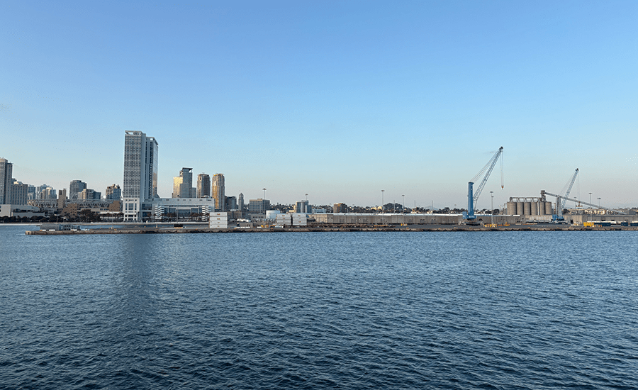 A marine port terminal against a San Diego downtown skyline at sunset.