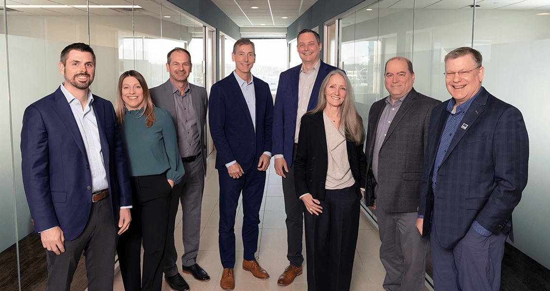 A group photo of the eight members of Barr's management team.