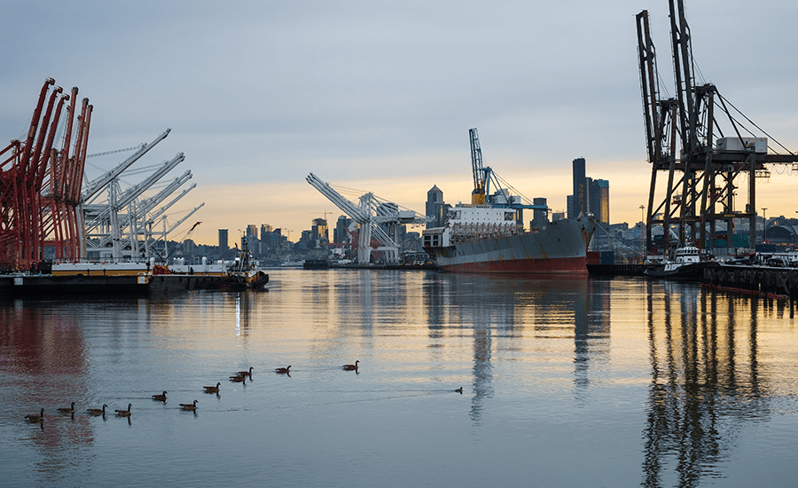 Industrial harbor with cargo ship and cranes.