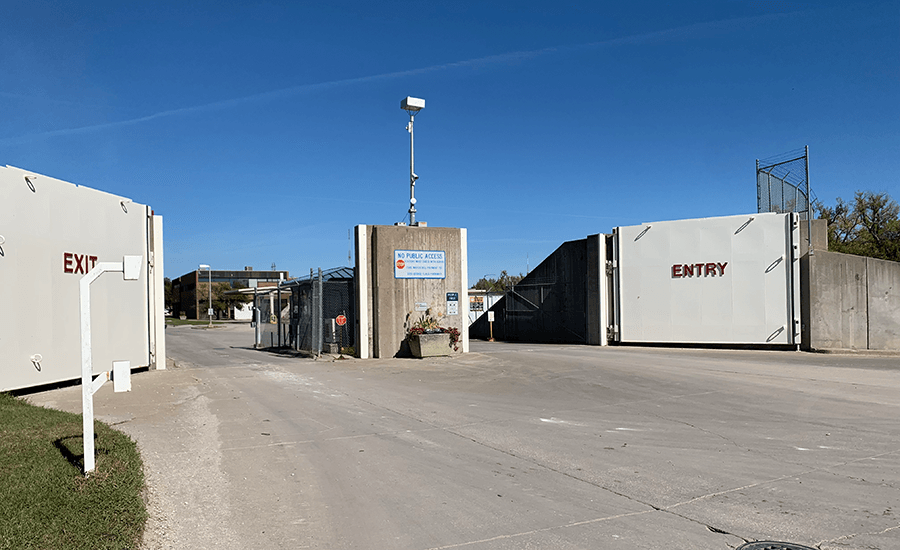 Open flood gates at the entrance to an industrial facility under a cloudless sky